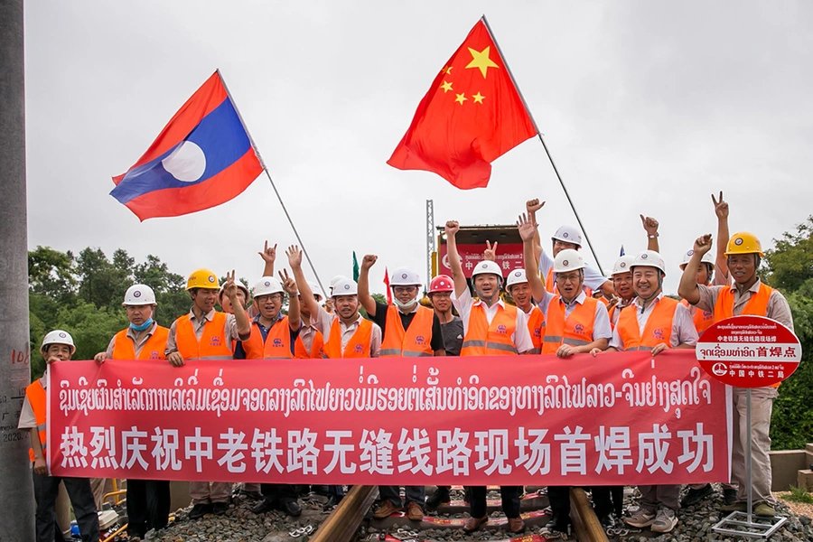 Workers from China Railway No.2 Engineering Group pose for a group photo after welding the first seamless rails for the China-Laos railway in the northern suburb of Vientiane, Laos, on June 18, 2020. 