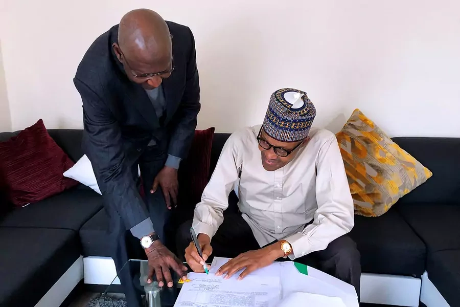 Nigeria's President Muhammadu Buhari signs into law a bill that amends legislation on agreements related to offshore oil production in Nigeria on November 4, 2019.