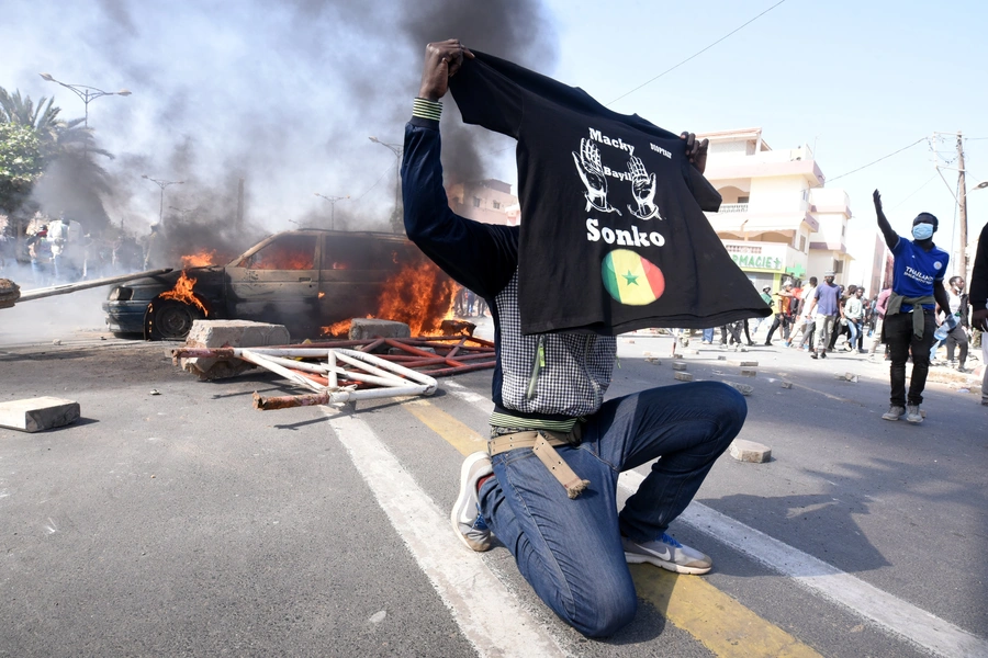 A supporter of opposition leader Ousmane Sonko holds a T-shirt reading "Macky, leave Sonko" during a protest in Dakar, Senegal March 8, 2021.