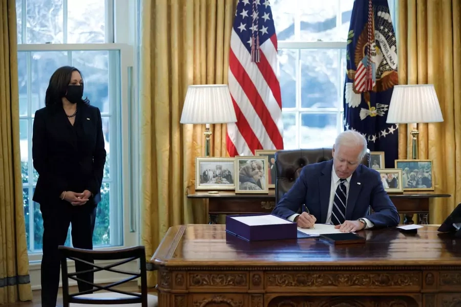 President Joe Biden signs the American Rescue Plan on March 11 (accompanied by Vice President Kamala Harris).