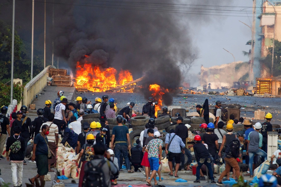 Anti-coup protesters stand at a barricade as they clash with security forces on Bayint Naung Bridge in Mayangone, Yangon, Myanmar, on March 16, 2021.