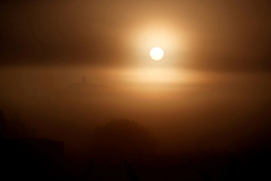 The sun rises behind Saint Michael's Church and Glastonbury Tor, in Glastonbury, Britain on November 4, 2020. 