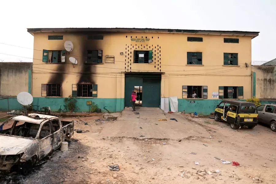 A man is seen standing in front of the main gate of the Nigerian Correctional Services facility that was attacked by gunmen, with large numbers of inmates set freed afterwards in Imo State, Nigeria on April 5, 2021.