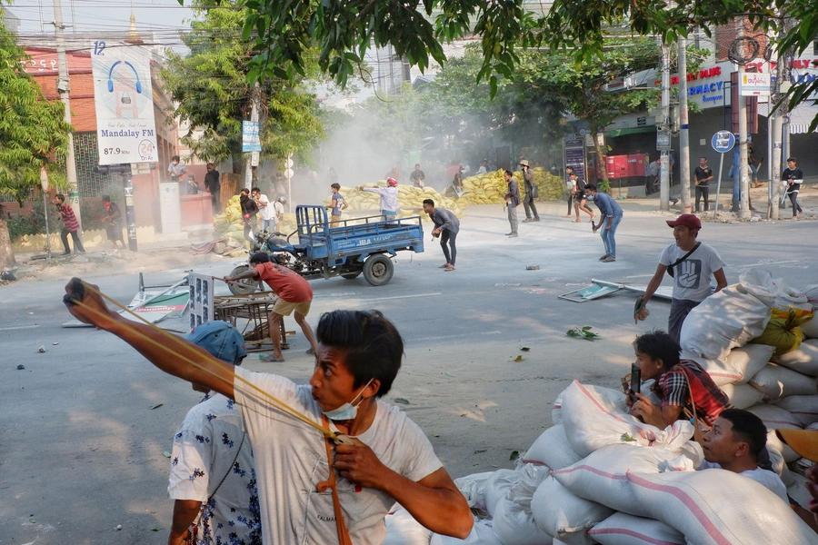 A man uses a slingshot during the security force crack down on anti-coup protesters in Mandalay, Myanmar, on March 14, 2021.