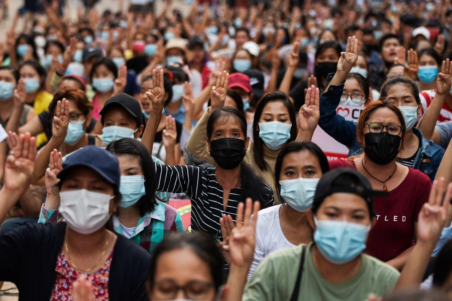 People flash a three-finger salute as they take part in an anti-coup night protest at Hledan junction in Yangon, Myanmar, March 14, 2021.