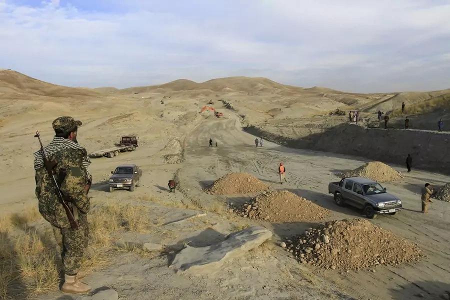 Afghan security personnel keep watch at a road construction site, which is being built by a Chinese company, in Khogyani district of Nangarhar Province on November 19, 2015.