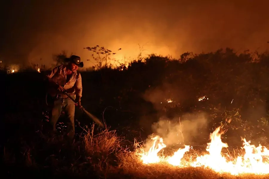 Sebastiao Baldi Silva Junior attempts to put out a fire on a ranch in the Pantanal, the world's largest wetland, in Pocone, Mato Grosso state in Brazil on August 26, 2020. 