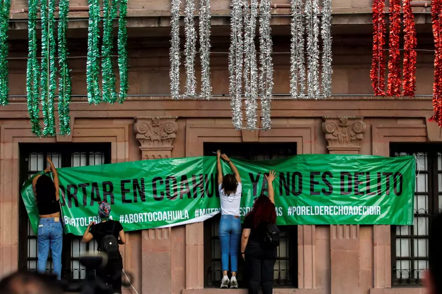 Women hang up a banner that says "Abortion in Coahuila is no longer a crime" following the Mexican Supreme Court ruling that decriminalized abortion.