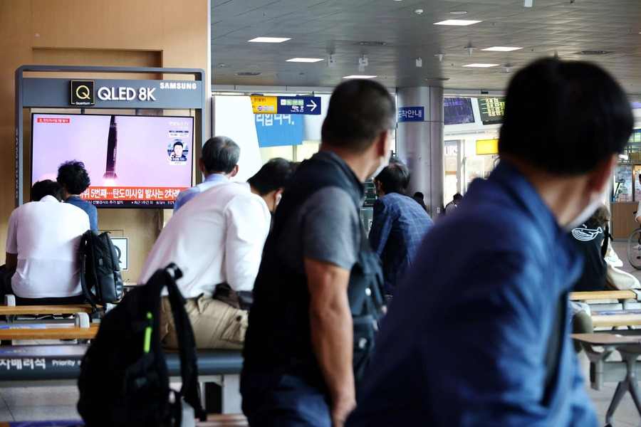 People watch a TV broadcasting file footage of a news report on North Korea firing what appeared to be a pair of ballistic missiles off its east coast, in Seoul, South Korea, September 15, 2021.