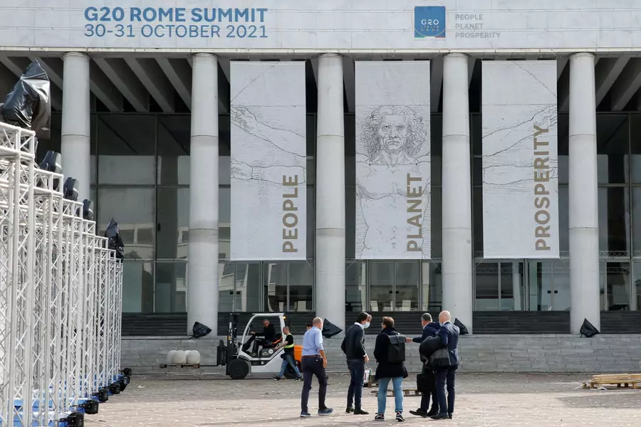 People stand in front of the G20 media center at the Palazzo dei Congressi in Rome, Italy, which will host the G20 summit from October 30-31 on October 22, 2021.