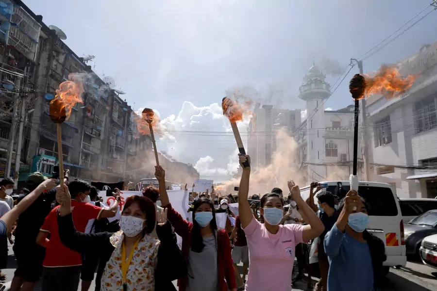A group of women hold torches as they protest against the military coup in Yangon, Myanmar, on July 14, 2021.
