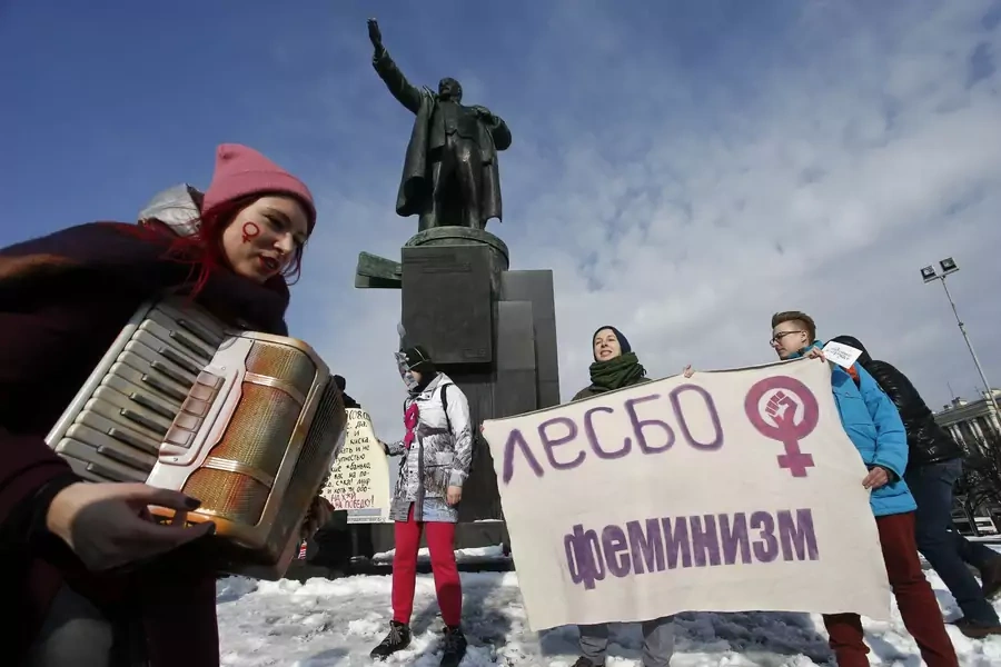 Participants attend a rally, held to support women's rights and to protest against violence towards women, with a monument to Soviet state founder Vladimir Lenin seen in the background, in Saint Petersburg, Russia March 8, 2019. 