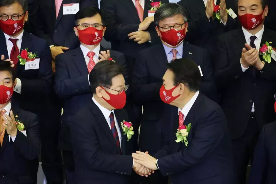 Yoon Seok-youl, the presidential election candidate of South Korea's main opposition People Power Party, shakes hands with Lee Jae-myung, the presidential election candidate of the ruling Democratic Party, in Seoul, South Korea on January 3, 2022.