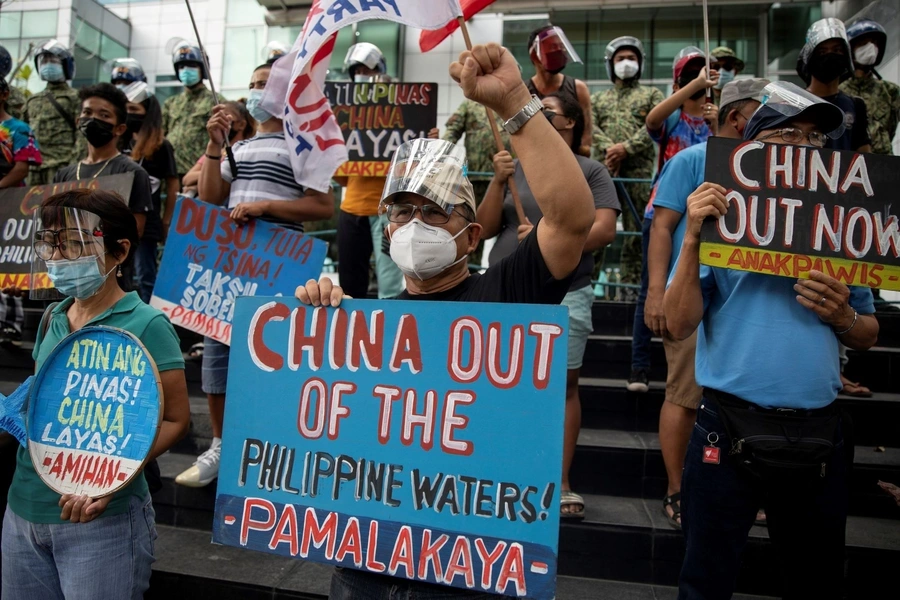 Activists stage a protest outside the Chinese Consulate, guarded by Philippine police, on the fifth anniversary of an international arbitral court ruling invalidating Beijing's historical claims over the waters of the South China Sea, in Makati City, Phil