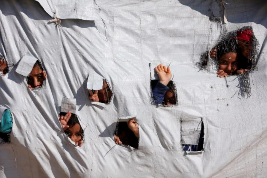 Children look through holes in a tent at al Hol displacement camp in Hasaka governorate, Syria on April 2, 2019.