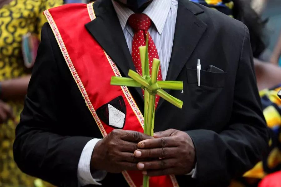 A Catholic devotee holds palm crosses to be blessed before a Palm Sunday mass at St. Dominic Catholic Church in Lagos, Nigeria on April 10, 2022