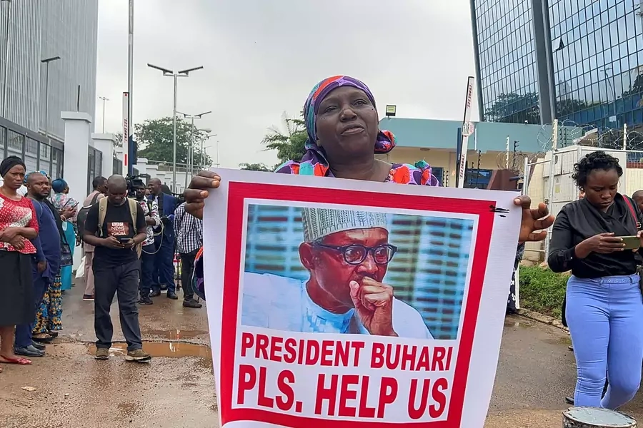 A woman holds a poster of Nigeria's president Muhammadu Buhari, as relatives of the Kaduna train kidnapped victims protest in Abuja, Nigeria on July 25, 2022.