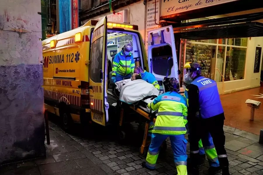 Emergency medical technicians load a patient into an ambulance during an outbreak of COVID-19 in Spain in November 2021.