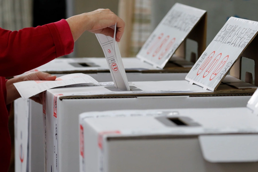 A woman casts her ballots at a polling station during local elections and referendum on same-sex marriage in Kaohsiung, Taiwan on November 24, 2018.