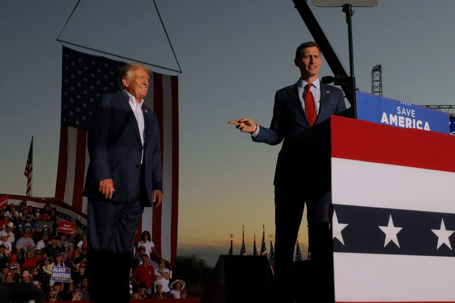 U.S. Senate candidate Blake Masters (R-AZ) speaks next to former U.S. President Donald Trump during a rally ahead of the midterm elections, in Mesa, Arizona, U.S., October 9, 2022.