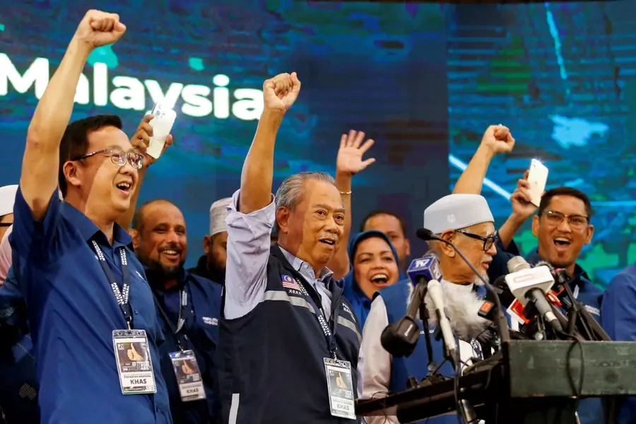 Malaysian former Prime Minister and Perikatan Nasional Chairman Muhyiddin Yassin raises hands with other leaders during a news conference after Malaysia's fifteenth general election in Shah Alam, Malaysia, November 20, 2022. 
