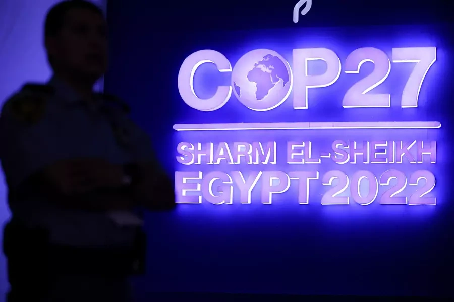 A security guard stands in front of the sign for the COP 27 climate summit in Sharm el-Sheikh, Egypt