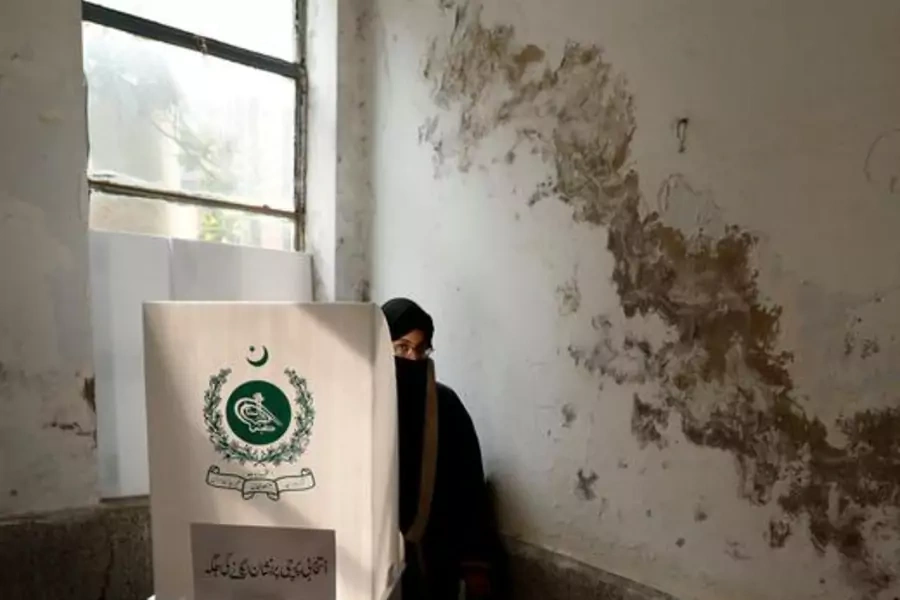 A woman casts her vote at a polling station during the 2018 general election in Rawalpindi, Pakistan. 