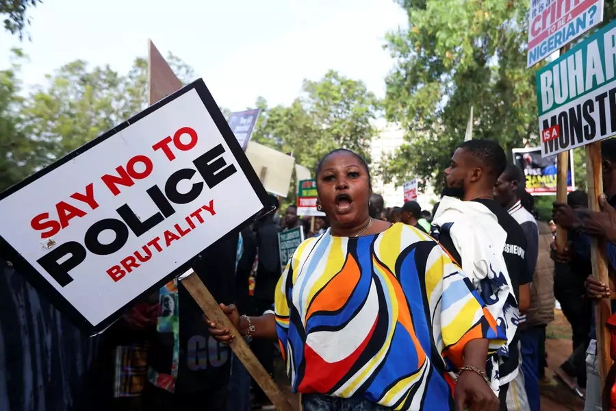 A protestor reacts as she holds a placard as Nigerians mark the one-year anniversary of the #EndSARS anti-police brutality protest in Abuja, Nigeria on October 20, 2021.