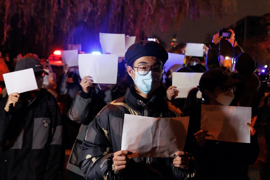 People hold white sheets of paper in protest of coronavirus disease (COVID-19) restrictions, after a vigil for the victims of a fire in Urumqi, as outbreaks of the coronavirus disease continue in Beijing, China, November 27, 2022. 