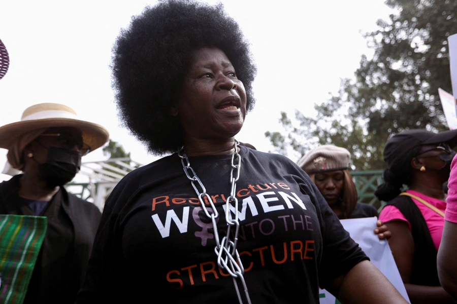 A woman wearing chains around her neck marches during a protest against legislative bias against women on International Women's Day in Abuja, Nigeria on March 8, 2022. The protest has been followed by a lockdown of the National Assembly Complex