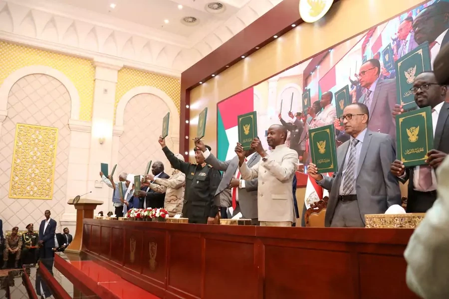Signatory parties stand and raise signed copies of the agreement between military rulers and civilian powers in Khartoum, Sudan on December 5, 2022.