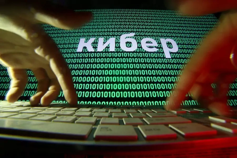 A person types as a line of text in Russian appears superimposed over a screen of computer code.