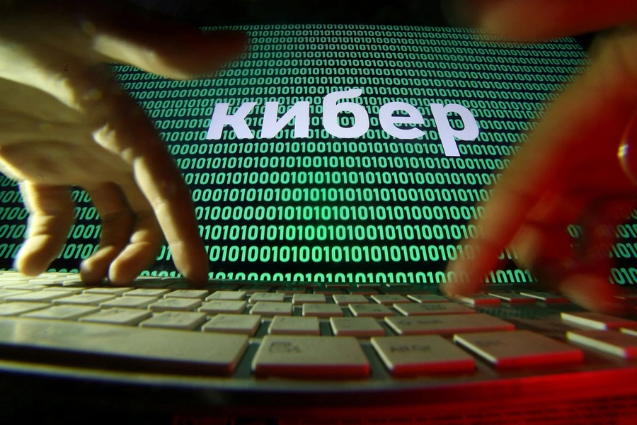 A person types as a line of text in Russian appears superimposed over a screen of computer code.