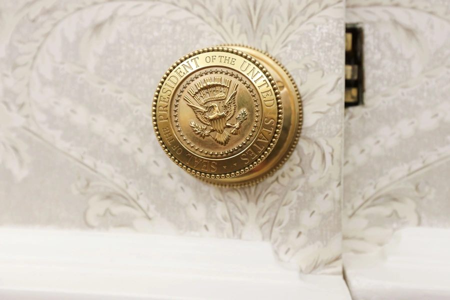 The official seal of the President of the United States on a doorknob in the Oval Office.