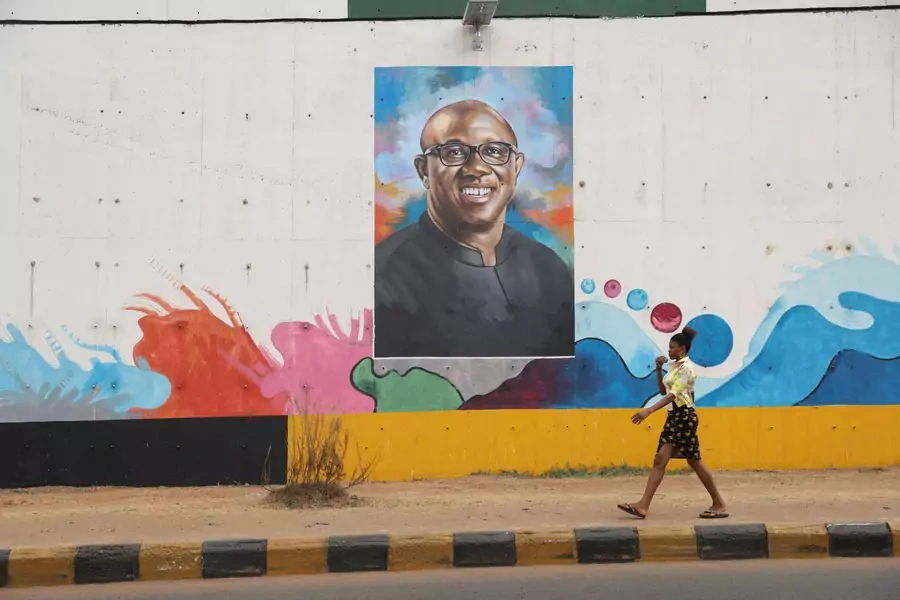 A woman walks past a graffiti depicting Labour Party (LP) Presidential candidate, Peter Obi, ahead of Nigeria's Presidential election in Awka, Anambra state, Nigeria on February 23, 2023.
