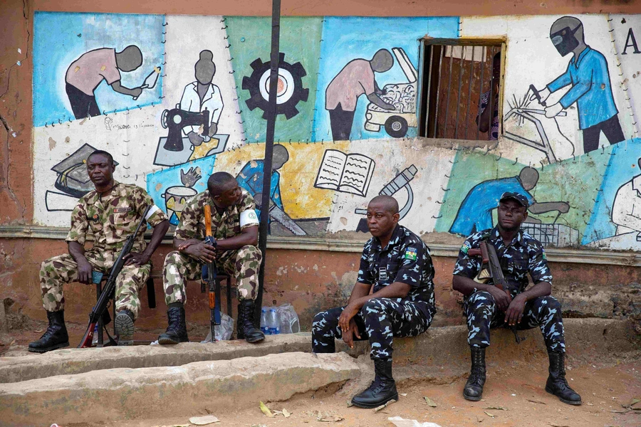 A day after the elections, soldiers and police guard the entrance to a vote collation center that was stormed earlier in the day by unknown assailants on February 26, 2023. 