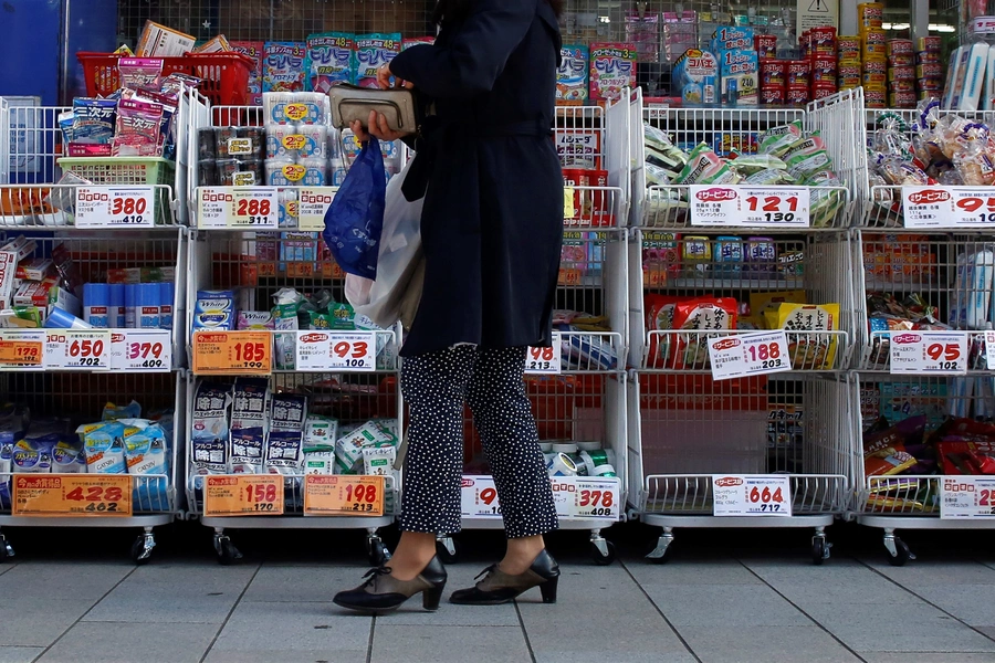 A woman stands outside a pharmacy in Tokyo April 7, 2014