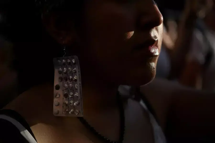 An abortion rights protester wears earrings made of birth control packets as protesters gather outside of the federal courthouse in downtown Houston, Texas, after the United States Supreme Court ruled in the Dobbs v Women's Health Organization abortion ca