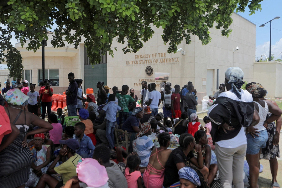 People escaping the threat of armed gangs rest under a tree as they camp in front of the U.S. Embassy, in Port-au-Prince, Haiti, July 25, 2023.