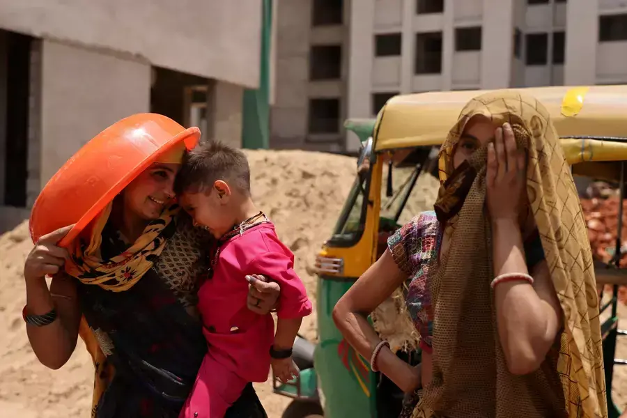 Women take shelter from the sun at a construction site in Ahmedabad, India, April 28, 2023.
