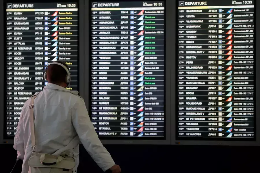 A man looks at a flight information board at the departure zone of Vnukovo International Airport in Moscow, Russia on December 30, 2020.