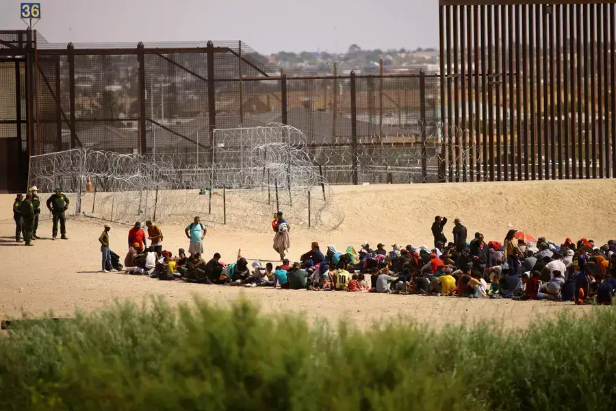 Venezualan migrants gather near the U.S. border wall after crossing the Rio Bravo river, as seen from Ciudad Juarez