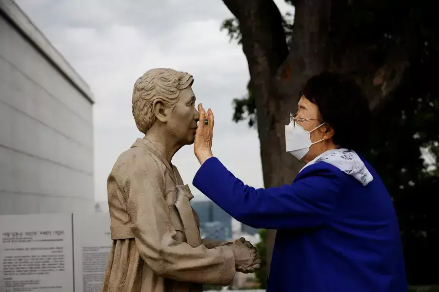 Former South Korean "comfort woman" Lee Yong-soo looks at a statue symbolising "comfort women" at the Seoul Comfort Women Memorial in Seoul, South Korea, June 29, 2021.