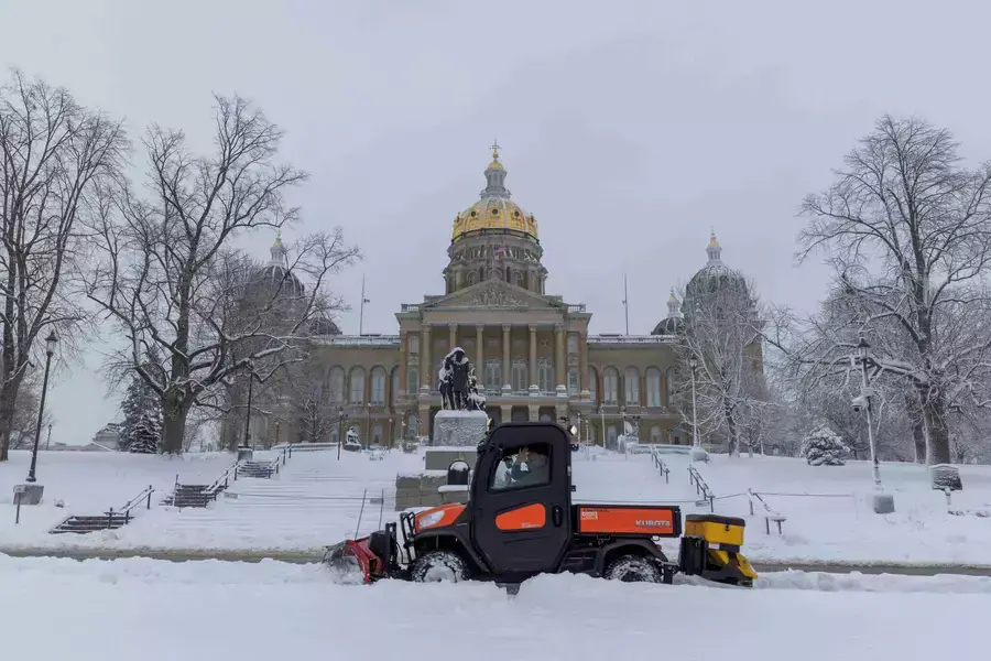 Workers remove snow in front of the State Capitol Building in Des Moines, Iowa, on January 9, 2024.