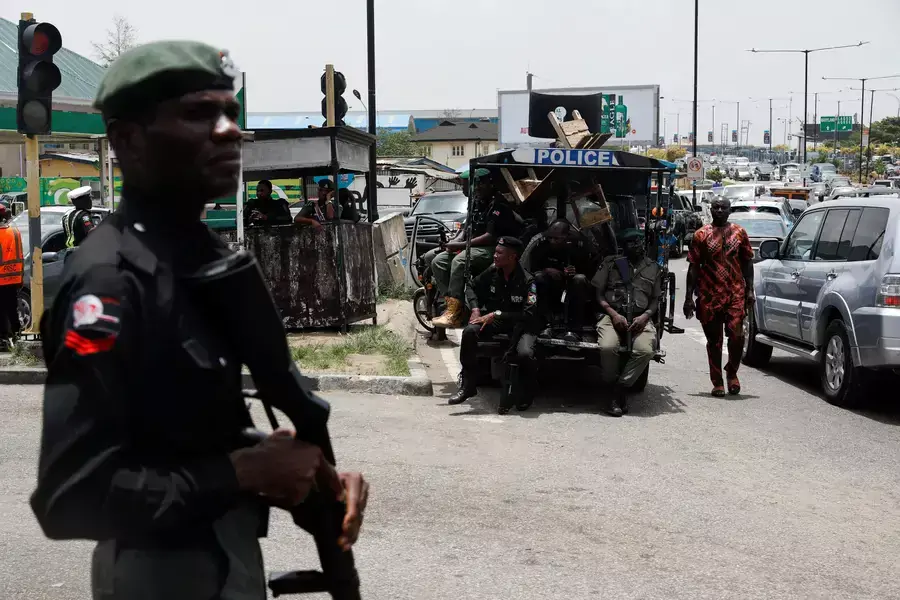 A man walks past police officers in position, as protesters block the domestic terminal of Murtala Muhammed International Airport during a strike over working conditions and wages, in Lagos, Nigeria on April 17, 2023.