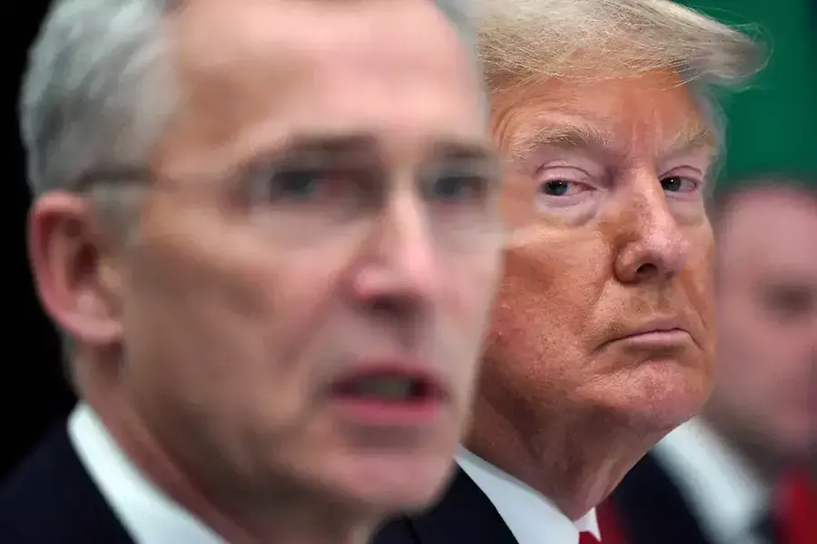 President Donald Trump sits next to NATO Secretary General Jens Stoltenberg at a NATO working lunch in Watford, Britain, on December 4, 2019.