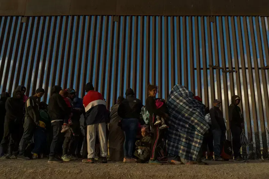 Migrants line up along the border in El Paso to surrender to U.S. immigration officials on March 25, 2024.