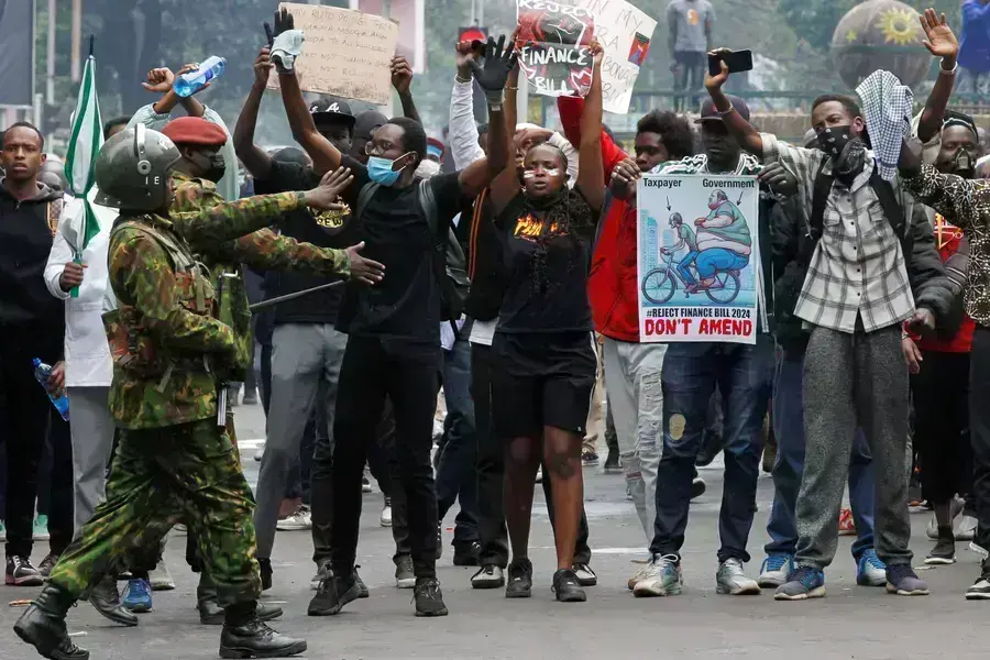 Protesters react after police use teargas to disperse them during a demonstration against Kenya's proposed finance bill in Nairobi, Kenya, on June 20, 2024.