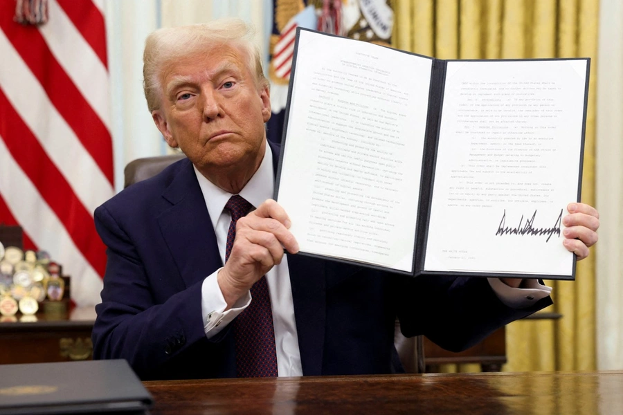 Donald Trump holds a signed executive order on cryptocurrencies in the Oval Office on January 23, 2025. 