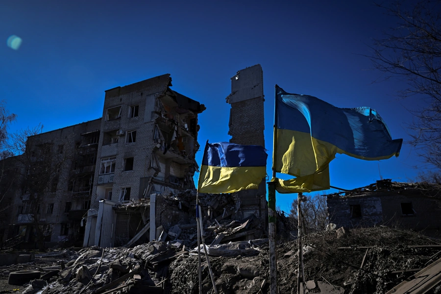Ukrainian national flags flutter in front of a heavily damaged apartment building in the frontline town of Orikhiv, Ukraine.